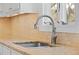 Close up of a kitchen sink with tile backsplash and granite countertops, showcasing the faucet and window view at 4801 Coon Club Rd, Meggett, SC 29449