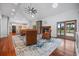 Open-concept living room with hardwood floors, fireplace, and seamless flow to kitchen and outdoor pool area at 4801 Coon Club Rd, Meggett, SC 29449
