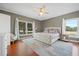 Bright main bedroom with large windows, hardwood floors, a plush bed, and neutral decor for a serene retreat at 4801 Coon Club Rd, Meggett, SC 29449