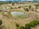 Scenic aerial view of a pond surrounded by tall grass and shrubbery with a home in the background at 4801 Coon Club Rd, Meggett, SC 29449