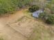 Aerial view of a large, fenced yard with lush trees surrounding a beautiful light blue home at 4801 Coon Club Rd, Meggett, SC 29449