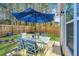 Backyard featuring a table set with umbrella, lush grass, and wooden fence at 5024 Wapiti Way, Hollywood, SC 29449