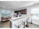 Open kitchen featuring dark cabinets, stainless steel appliances, and a breakfast bar with white chairs at 5024 Wapiti Way, Hollywood, SC 29449