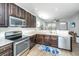 Well-lit kitchen boasts stainless steel appliances, dark wood cabinets, and access to the living area at 5024 Wapiti Way, Hollywood, SC 29449