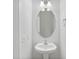 Elegant half bath features a pedestal sink, oval mirror, and modern lighting fixtures at 505 Greywood Ln, Goose Creek, SC 29445