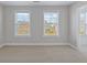 A room with neutral walls and carpet, two windows, and a doorway, creating a bright, adaptable space at 505 Greywood Ln, Goose Creek, SC 29445