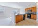Open kitchen with dark appliances, an island sink, wood cabinets, and tile flooring at 505 Greywood Ln, Goose Creek, SC 29445