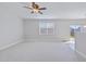 Spacious living room with plush carpeting, a ceiling fan, and a sliding glass door to the backyard at 505 Greywood Ln, Goose Creek, SC 29445