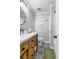 A well-lit bathroom with a wood vanity, white countertop, round mirror and decorative tile floor at 507 Stinson Dr # 5E, Charleston, SC 29407