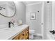 Well-lit bathroom with a wood vanity, white countertop, round mirror and decorative tile floor at 507 Stinson Dr # 5E, Charleston, SC 29407