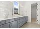 Modern bathroom features a double vanity with gray cabinets, white countertop, and window at 509 Rhythm St, Summerville, SC 29486