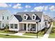 Charming single Gathering home featuring a cozy front porch, dormer windows, and manicured lawn at 509 Rhythm St, Summerville, SC 29486