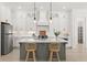Bright kitchen features custom white cabinetry, pendant lighting, stainless appliances, and a center island with seating at 509 Rhythm St, Summerville, SC 29486