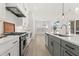 Open kitchen featuring a large center island with sink, stainless steel appliances, and custom cabinetry at 509 Rhythm St, Summerville, SC 29486