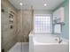 Modern bathroom featuring a glass shower and a luxurious soaking tub with tiled surround at 520 Sanders Farm Ln, Wando, SC 29492