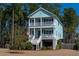 Charming two-story coastal home with double porches and a well-manicured front yard nestled amongst mature trees at 520 Sanders Farm Ln, Wando, SC 29492
