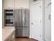Close-up of stainless steel appliances including a refrigerator, double oven and countertop with white cabinets at 520 Sanders Farm Ln, Wando, SC 29492