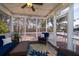 Comfortable screened-in porch with wicker furniture and views of the surrounding trees at 520 Sanders Farm Ln, Wando, SC 29492