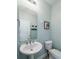 Simple powder room featuring a pedestal sink, toilet, framed art, and light blue walls at 520 Sanders Farm Ln, Wando, SC 29492