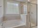 Bright bathroom featuring garden tub, tiled walls, and glass shower at 525 Verdi Dr, Summerville, SC 29486