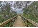 Scenic boardwalk view with lush foliage leading to tranquil waters under a partly cloudy sky at 5408 Overland Trl, North Charleston, SC 29420