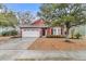 Charming red one-story home featuring a well-manicured lawn and attached two-car garage at 5408 Overland Trl, North Charleston, SC 29420
