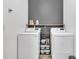 Laundry room with white washer and dryer on either side of a black storage shelf at 5408 Overland Trl, North Charleston, SC 29420