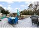 Wooden deck with multiple tables and chairs, and a screened-in porch at 5529 Golden Rice Ln, Ravenel, SC 29470