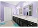 Bathroom featuring double sinks with black cabinetry, a white countertop and purple walls at 5529 Golden Rice Ln, Ravenel, SC 29470