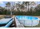 Backyard showcasing an above ground pool and deck with outdoor seating for lounging and relaxation at 5529 Golden Rice Ln, Ravenel, SC 29470