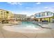 Expansive zero entry pool with plentiful lounge seating surrounded by tropical landscaping and resort hotel buildings at 5804 Palmetto Dr # A-208, Isle of Palms, SC 29451
