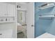 Bathroom view showcases stylish wall shelves and provides a glimpse into the bedroom with a ceiling fan at 6244 Lucille Dr # B, North Charleston, SC 29406