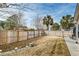 Spacious backyard with mature trees, partial privacy fence, and charming seating area at 7034 Lanier St, Hanahan, SC 29410