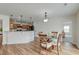 Open dining area featuring hardwood floors, glass table, and easy access to the kitchen at 7034 Lanier St, Hanahan, SC 29410