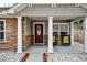 Cozy front porch with decorative columns, seating, and a charming front door at 7034 Lanier St, Hanahan, SC 29410