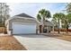 Charming home exterior featuring a garage with a driveway and landscaped front yard at 7034 Lanier St, Hanahan, SC 29410