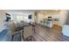 Open-concept dining area featuring wood floors, a large dining table, and a kitchen with bar seating at 744 Pisces Ln, Summerville, SC 29486