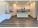 Modern kitchen with a center island, granite countertops, stainless steel appliances and sleek new floors at 744 Pisces Ln, Summerville, SC 29486