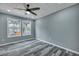 Cozy bedroom featuring two windows, gray walls, gray flooring, and a ceiling fan at 7461 Church Hill Rd, Hollywood, SC 29449