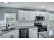 Close up of a kitchen featuring white cabinets, granite countertops, and stainless steel appliances at 7461 Church Hill Rd, Hollywood, SC 29449
