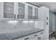 Upper kitchen cabinets with glass fronts, white backsplash, and granite countertops at 7461 Church Hill Rd, Hollywood, SC 29449