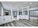 Open-concept kitchen with white cabinets, granite countertops, and gray wood-look flooring at 7461 Church Hill Rd, Hollywood, SC 29449