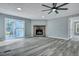 Cozy living room with stone fireplace, sliding glass doors, and modern ceiling fan at 7461 Church Hill Rd, Hollywood, SC 29449