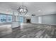 Spacious living room with modern chandelier, bar, and stone fireplace, well-lit with lots of windows at 7461 Church Hill Rd, Hollywood, SC 29449