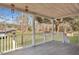 Covered porch features gray tiled floors and white railing overlooking lush backyard at 7461 Church Hill Rd, Hollywood, SC 29449