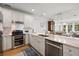 Open-concept kitchen boasts stainless steel appliances, white cabinets, marble counters, and connects to dining and living areas at 801 Balgrove Ct # 801, Mount Pleasant, SC 29466