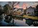 Aerial view of a home and backyard with private dock on the water at sunset at 810 Harbor Place Dr, Charleston, SC 29412
