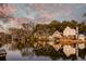 Waterfront home with a wooden deck overlooking the water with a sunset visible in the sky at 810 Harbor Place Dr, Charleston, SC 29412