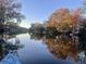 Scenic waterfront homes reflected in the calm water, surrounded by trees in autumn colors, creating a tranquil and picturesque view at 810 Harbor Place Dr, Charleston, SC 29412