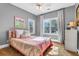 Bright bedroom features a ceiling fan, a large window with curtains, and a cozy bed with striped quilt at 904 Watermelon Run, Charleston, SC 29412